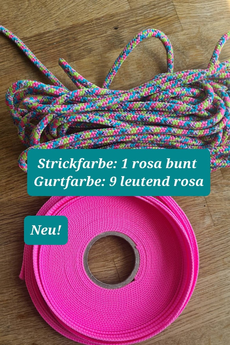 Pu&ograve; includere: Una corda rosa e verde con il testo "Strickfarbe: 1 rosa bunt Gurtfarbe: 9 leutend rosa Neu!" e un cinturino rosa.