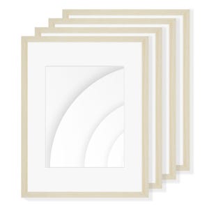 Puede incluir: Una pila de cuatro marcos de fotos rectangulares con acabado de madera clara. Cada marco tiene un paspartú blanco y una abertura rectangular. Los marcos están dispuestos en ángulo, mostrando su diseño y potencial para exhibir obras de arte o fotos.