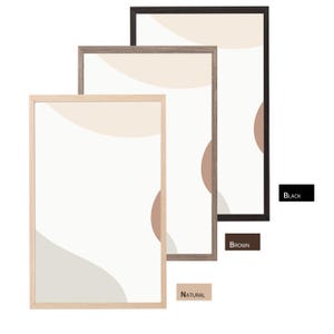 May include: Three framed abstract art prints in natural, brown, and black frames. Each print features a minimalist design with beige, brown, and grey shapes on a white background. The frames are rectangular and vary in wood tones.