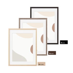 May include: Three framed art prints with abstract designs in neutral colors. The frames are in black, brown, and natural wood tones. The artwork features soft shapes in beige, tan, and brown against a white background. The word "BLACK", "BROWN", and "NATURAL" are written on the image.