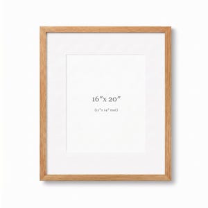 May include: A rectangular wooden picture frame with a white mount. The frame is 40.6 cm x 50.8 cm with a 27.9 cm x 35.6 cm mount. The frame is made of light-colored wood and has a simple design.