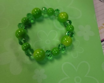 May include: A green beaded bracelet with alternating round and faceted beads.