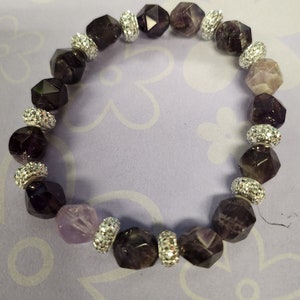 Könnte beinhalten: Ein violettes und silbernes Armband mit facettierten Perlen und silbernen Akzenten.