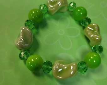 May include: A green and white bracelet with ceramic beads and green glass beads.