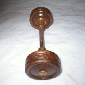 May include: A pair of wooden door knobs with brass accents. The knobs are round and have a grooved design.