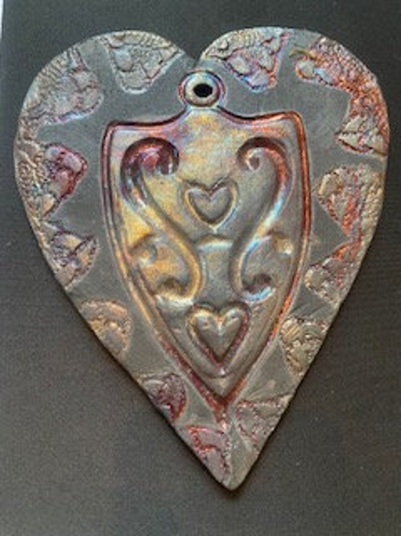 A heart embossed shape pressed into a Raku clay piece, bisque fired, then raku glazed fired outside in raku kiln. copper, gold colors image 2