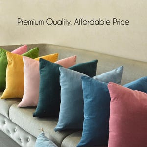 Peut inclure: Plusieurs coussins décoratifs en velours de couleurs vives, rose, vert, jaune et bleu, sont disposés sur un canapé gris. Les coussins ont un aspect doux et texturé. Le texte sur le mur indique "Premium Quality, Affordable Price."
