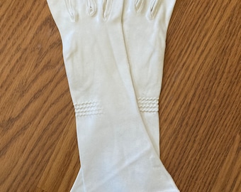 May include: A pair of long white gloves with a decorative stitch detail at the wrist.