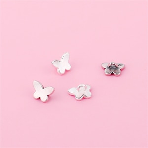 May include: Four silver butterfly charms with a loop for attaching to a bracelet or necklace.