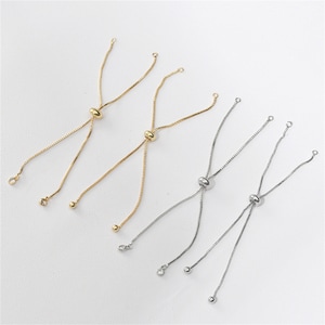 Puede incluir: Cuatro cordones de pulsera ajustables con una cuenta deslizante y un pequeño cristal en cada extremo. Dos cordones son dorados y dos son plateados.