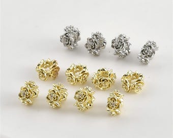 May include: A collection of small, decorative beads in the shape of roses. The beads are in two colors: gold and silver. Each rose bead has a small, clear gem in the center.