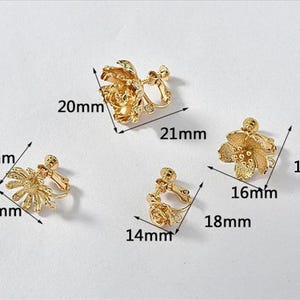 May include: Three pairs of gold-tone clip-on earrings with floral designs. The earrings are approximately 1.5 inches, 1.6 inches, and 1.9 inches in diameter.