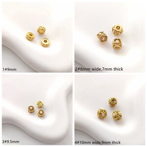 May include: Four different sizes of gold-tone metal beads with a filigree design and a small white pearl in the center. The beads are 9mm, 8mm wide by 7mm thick, 9.5mm, and 10mm wide by 9mm thick.