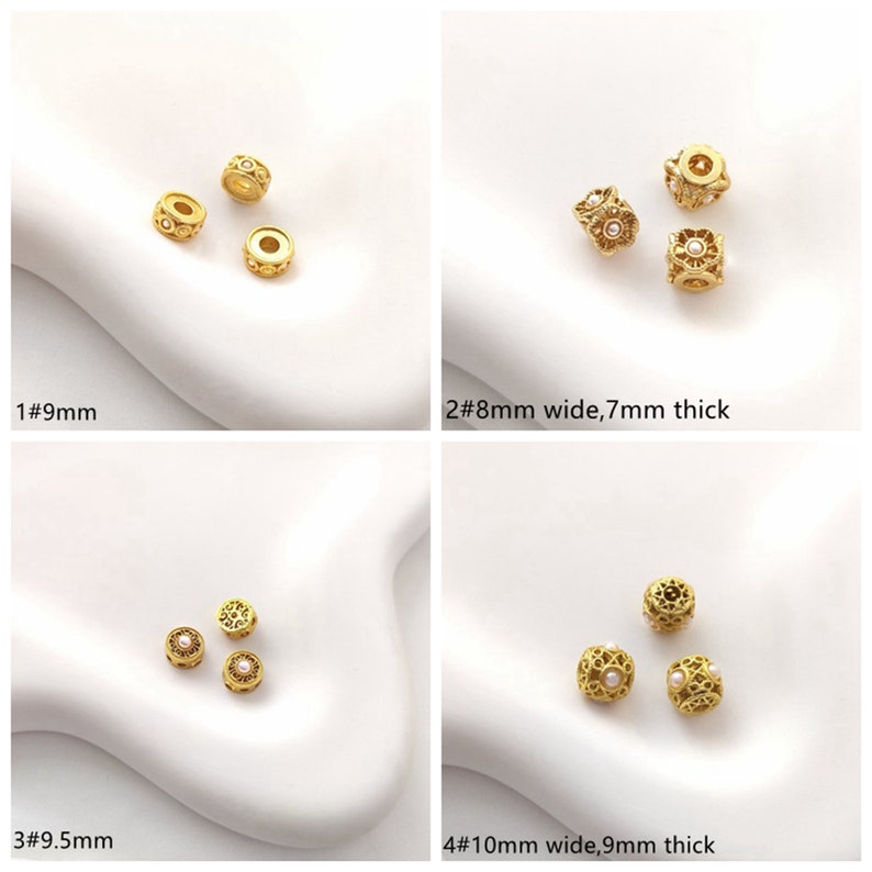 May include: Four different sizes of gold-tone metal beads with a filigree design and a small white pearl in the center. The beads are 9mm, 8mm wide by 7mm thick, 9.5mm, and 10mm wide by 9mm thick.