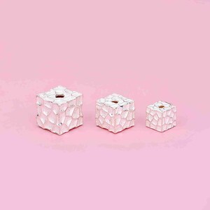 May include: Three silver cube beads with a textured surface and a hole in the center. The beads are arranged in order of size, with the largest bead on the left and the smallest bead on the right.