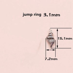 K&ouml;nnte beinhalten: Silberner Muschel-Anh&auml;nger mit einem Sprungring. Der Anh&auml;nger ist 15,1 mm hoch und 7,2 mm breit.