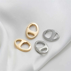 May include: Four metal oval-shaped clasps, two gold and two silver, with a spring-loaded opening.