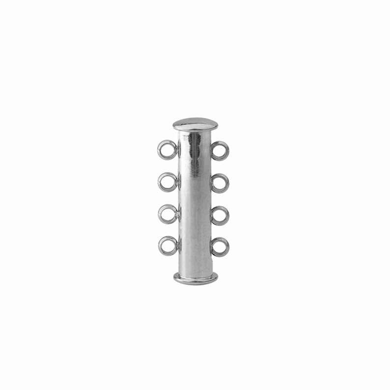 May include: A silver-toned cylindrical jewelry clasp featuring four small circular loops on each side, designed for connecting multiple strands of jewelry. The metal component has a smooth, reflective finish with a flat cap at the top and bottom.