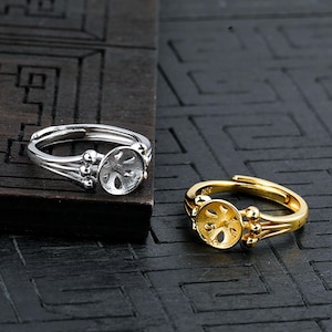 Op de afbeelding: Twee zilveren ringen met een ronde, open achterkant. De ringen hebben een delicaat, gedraaid ontwerp en zijn versierd met kleine kralen.