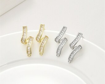 May include: Two pairs of earrings with a zig-zag design. One pair is gold with clear cubic zirconia stones, and the other pair is silver with clear cubic zirconia stones.