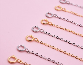 May include: A set of six gold and silver extender chains for necklaces. The chains are made of small, round links and have a lobster clasp closure.