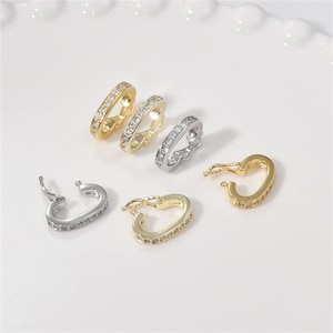 May include: Four gold and silver tone metal clasps with clear crystal accents. The clasps are designed for necklaces or bracelets.