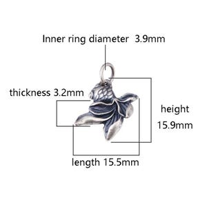 K&ouml;nnte beinhalten: Silberner Anh&auml;nger in Form eines Goldfisches. Der Anh&auml;nger ist 15,5 mm lang, 15,9 mm hoch und 3,2 mm dick. Der Innendurchmesser des Rings betr&auml;gt 3,9 mm.