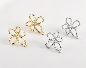 May include: Three flower-shaped earring findings with clear rhinestones. The findings are made of metal and have a loop on the bottom for attaching earrings.