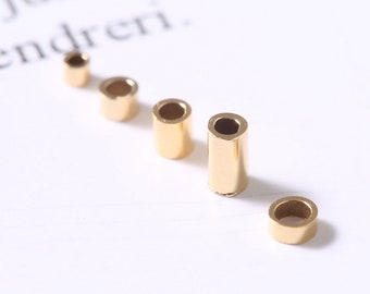 May include: Five gold-colored metal jump rings of varying sizes. The rings are arranged in a line from largest to smallest.