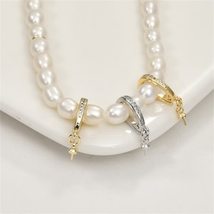 May include: Two pearl necklace clasps with a row of clear cubic zirconia stones. One clasp is gold-toned and the other is silver-toned.