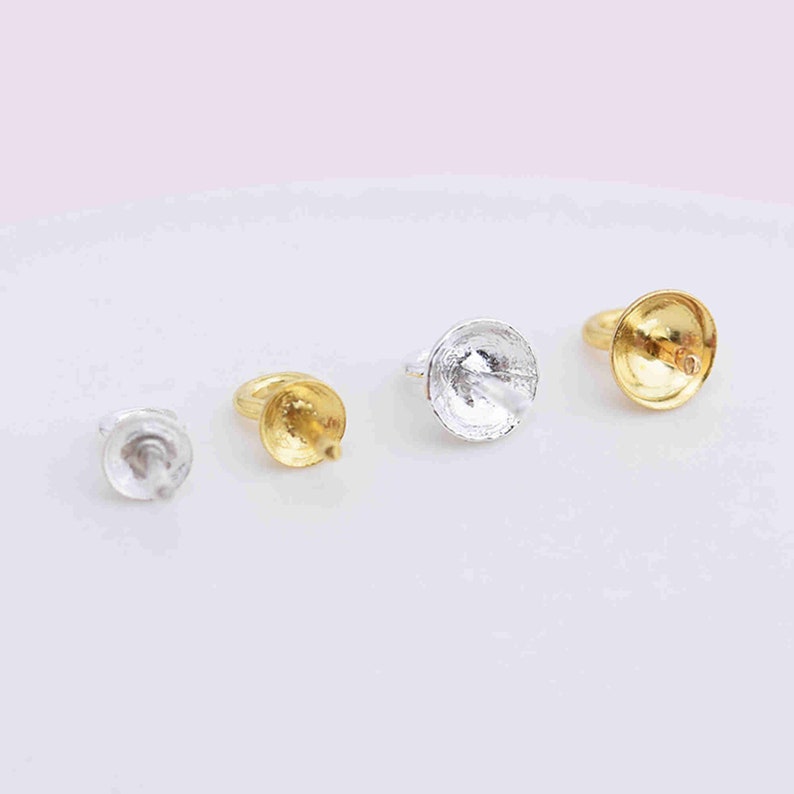 Puede incluir: Cuatro fornituras para joyer&iacute;a dispuestas en fila, que consisten en dos tapas para cuentas de metal plateado y dos de metal dorado. Cada pieza presenta una parte superior en forma de peque&ntilde;a copa circular con un pin central y una anilla lateral.