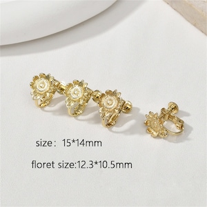 May include: Gold-tone clip-on earrings with a sunflower design. The earrings measure 1.5 inches by 1.4 inches. Each sunflower measures 1.2 inches by 1.0 inches.