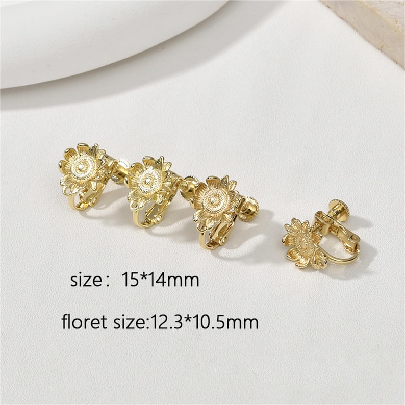 May include: Gold-tone clip-on earrings with a sunflower design. The earrings measure 1.5 inches by 1.4 inches. Each sunflower measures 1.2 inches by 1.0 inches.