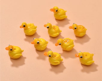 May include: Nine yellow rubber duck figurines with orange beaks and eyes. The ducks are arranged in a semi-circle on a light orange background.