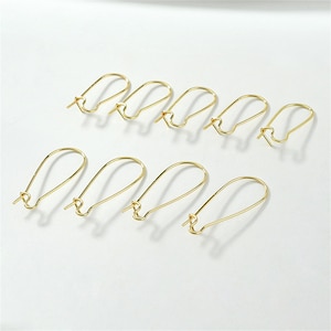 May include: Ten gold-toned earring hooks, each with a teardrop-shaped loop. The hooks are arranged in two rows of five.