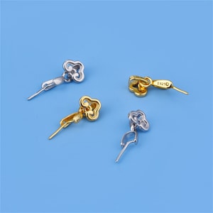 Può includere: Quattro chiusure a forma di fiore in tono argento e oro per la creazione di gioielli. Le chiusure hanno un piccolo anello a un'estremità e uno spillo all'altra estremità. Le chiusure sono utilizzate per fissare collane, braccialetti e altri gioielli.