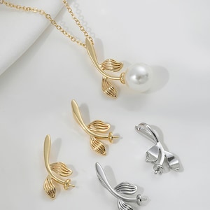 Op de afbeelding: Een set gouden en zilveren bladhangerbedels met een parelbezetting. De bedels hebben een delicaat bladontwerp met een kleine lus aan de bovenkant om aan een ketting of armband te bevestigen.