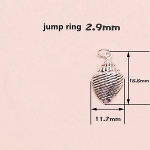 K&ouml;nnte beinhalten: Silberner Muschel-Anh&auml;nger mit strukturierter Oberfl&auml;che. Der Anh&auml;nger ist 1,8 cm hoch und 1,1 cm breit. Der Sprungring ist 2,9 mm gro&szlig;.