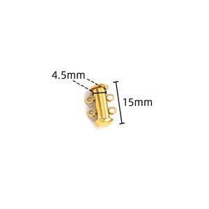 May include: A gold-colored cylindrical jewelry clasp featuring two small loops on each side for attachment. The component measures 15mm in total length and 4.5mm in width, as indicated by the black measurement lines and text labels visible in the image.