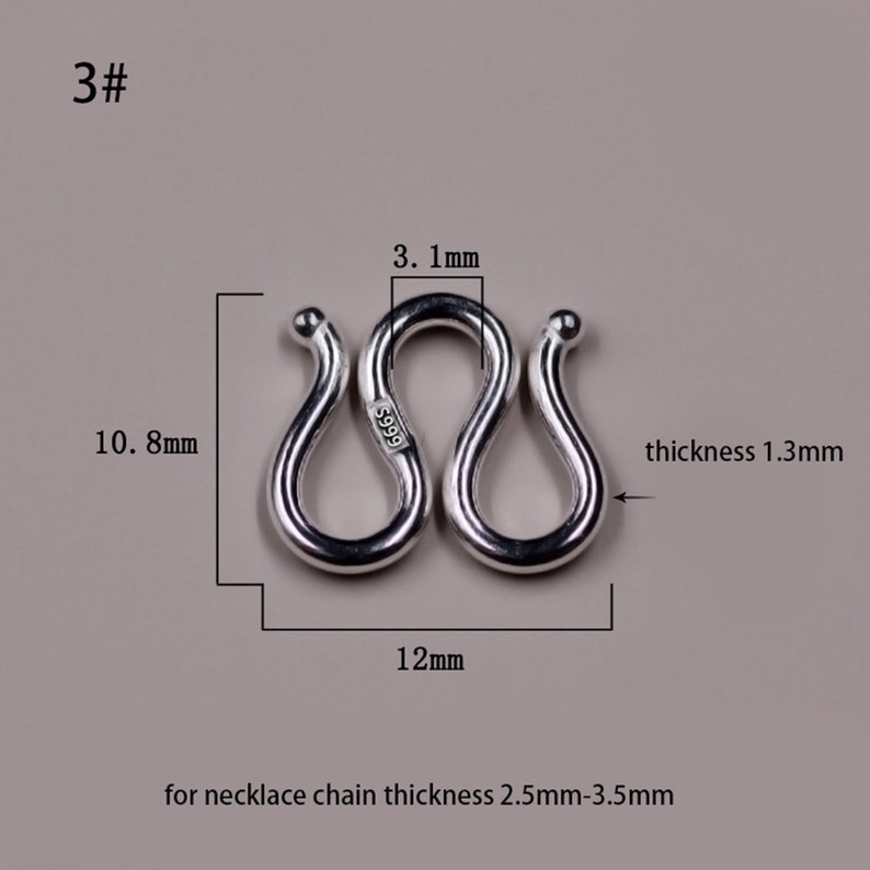 May include: Silver S-shaped connector for necklaces, measuring 12 mm in length and 10.8 mm in height. The connector is 1.3 mm thick and marked with "S999" for 99.9% silver purity. It is designed for necklace chains with a thickness of 2.5 mm to 3.5 mm.