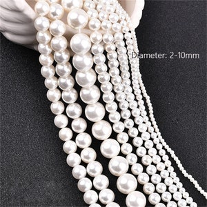 May include: A strand of white pearl beads in various sizes, ranging from 2 to 10 millimeters in diameter.  The beads are arranged in rows, with the largest beads at the top and the smallest beads at the bottom.  Diameter: 2-10mm