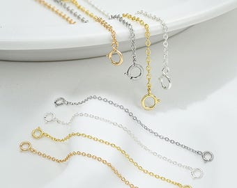 May include: Set of six gold, silver, and rose gold extender chains for necklaces or bracelets. Each chain has two jump rings at the ends.