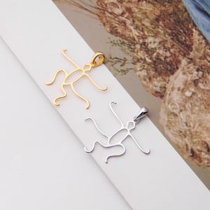 May include: Two metal pendants in the shape of a cricket. One pendant is gold and the other is silver.