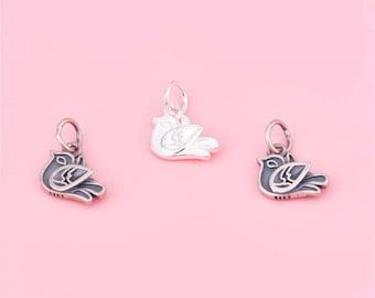 May include: Three silver dove charms, one is silver, one is oxidized silver, and one is silver with a black enamel finish.