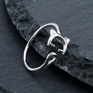 May include: Silver ring with a cat design. The cat is curled up in a sleeping position.