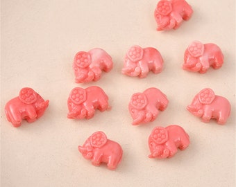 May include: Ten pink elephant shaped beads with a white swirl design. The beads are made of a smooth, glossy material.