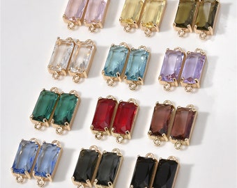 May include: Assortment of 12 pairs of gold-toned rectangular connector charms with various coloured glass stones. Each charm has two loops for attaching to jewellery.