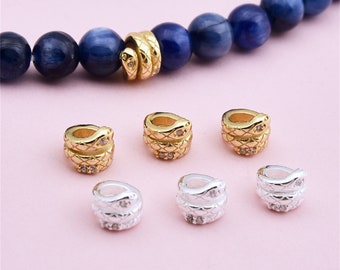 May include: Six snake-shaped bead spacers for jewelry making. Two are gold with clear rhinestones and four are silver with clear rhinestones.