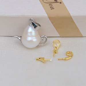May include: A white pearl teapot pendant with a silver finish. The pendant comes with a gold-tone jump ring, a gold-tone bail, and a gold-tone loop.