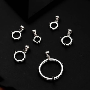 Puede incluir: Seis engastes de plata para colgantes con biseles redondos de diferentes tamaños. Los engastes están sobre una superficie negra.